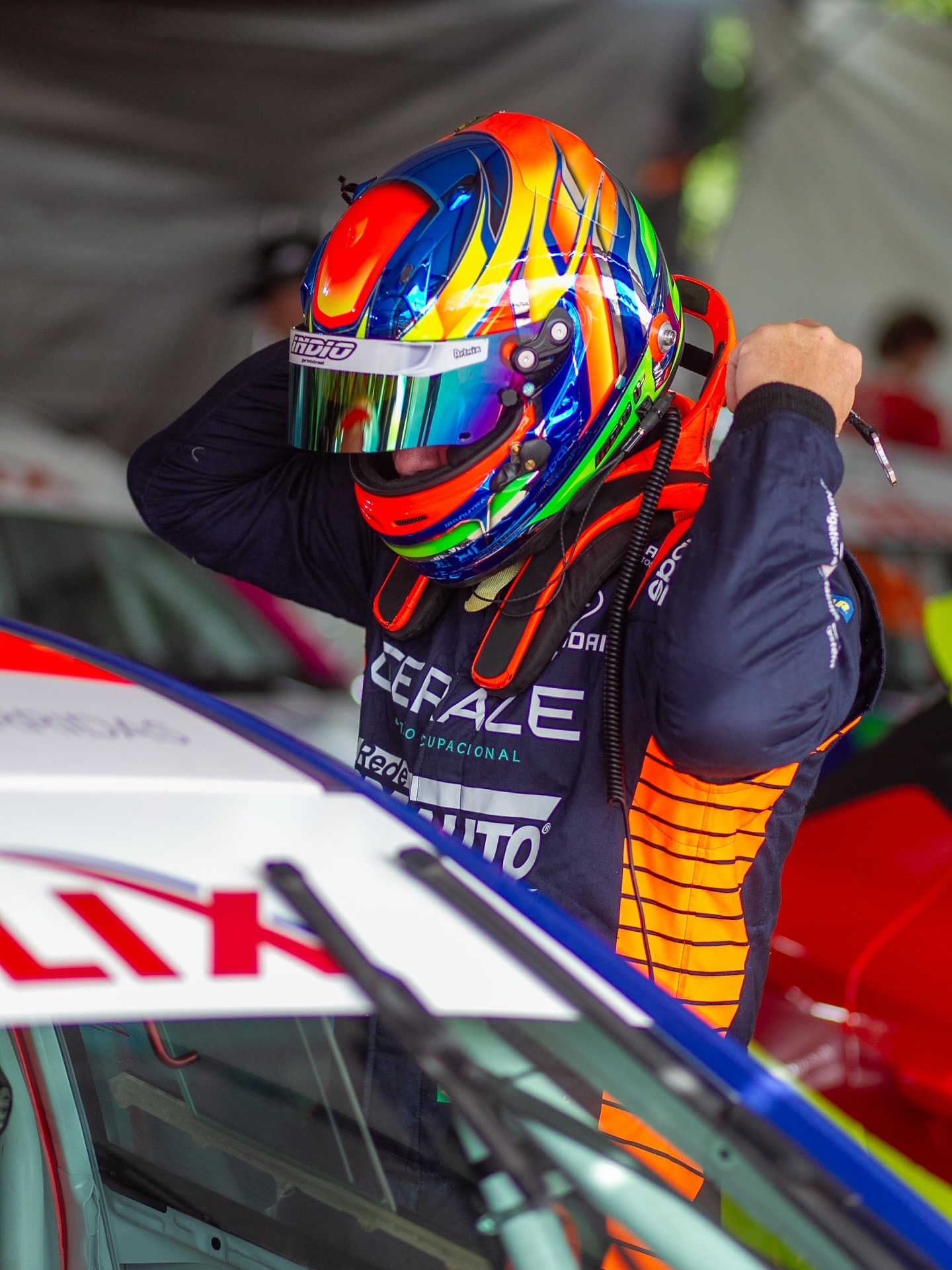 Marcus Índio com capacete ao lado do carro #21 nos boxes